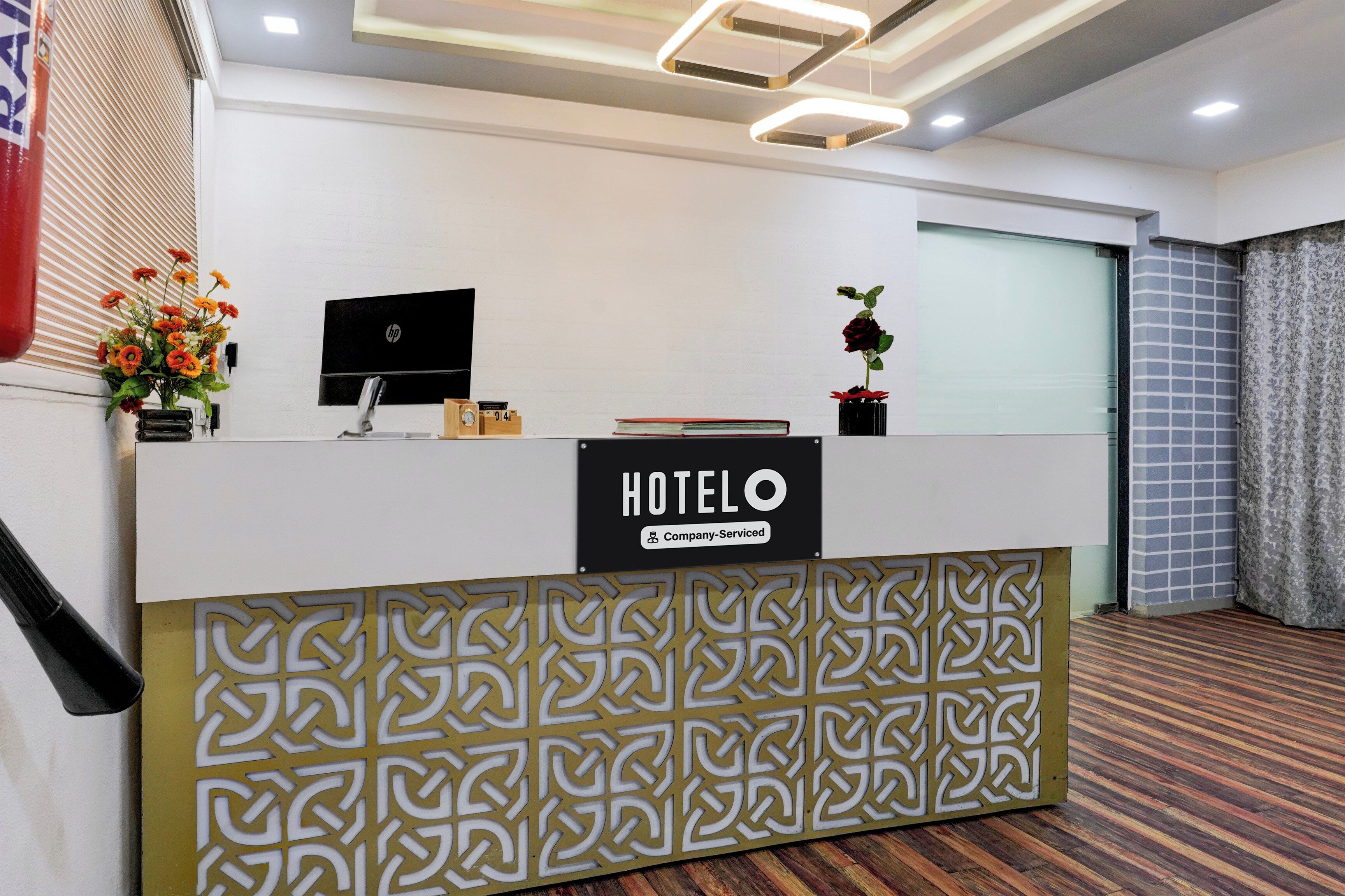 A hotel reception desk with a sign that reads 'HOTELO Company Serviced.'