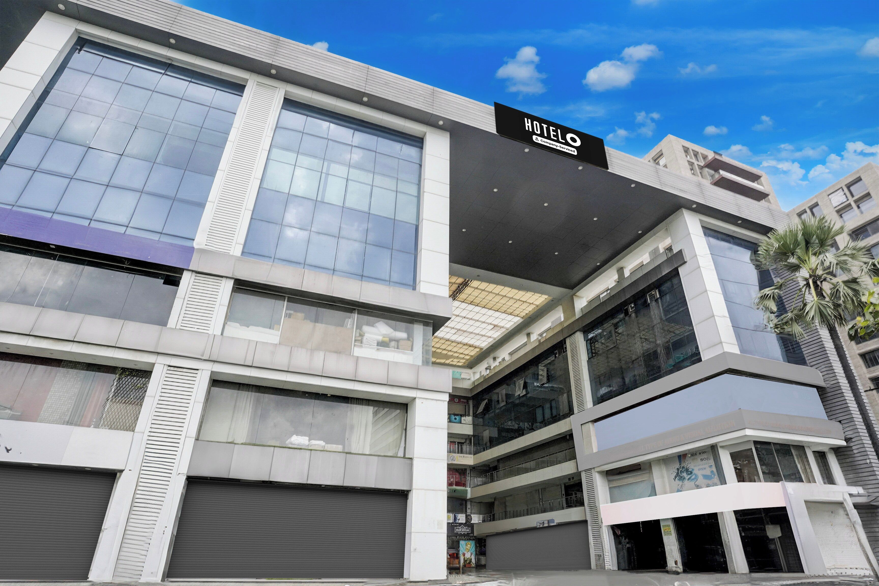 A modern hotel with a prominent 'HOTEL' sign, large windows, and a multi-story structure.