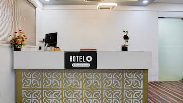 Una recepción de hotel con un letrero que indica que el servicio es proporcionado por la empresa.