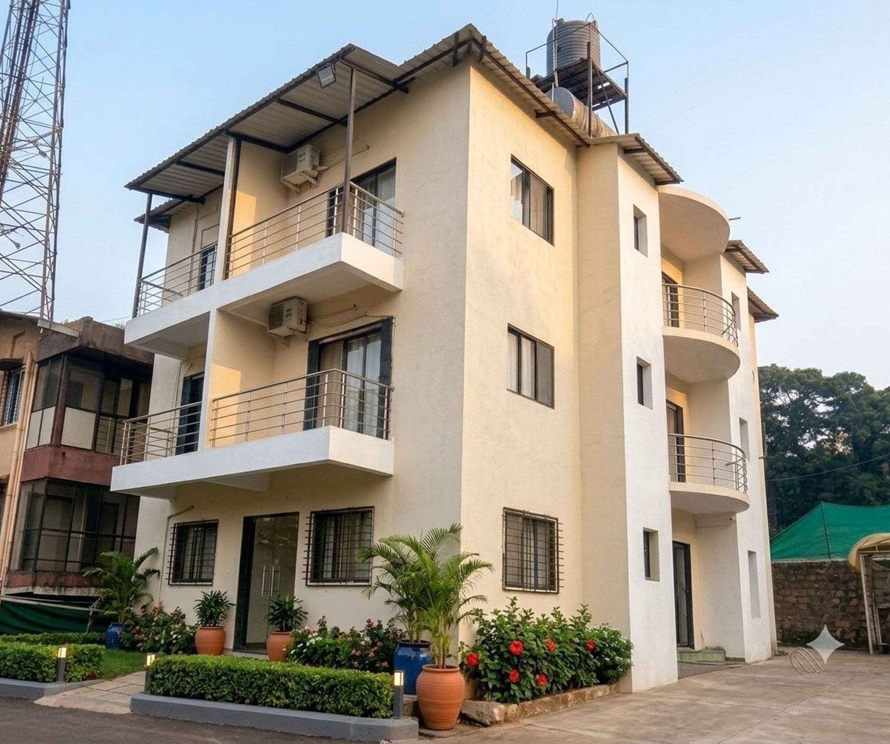 A multi-story residential building with balconies, air conditioning units, and a water tank on the roof.