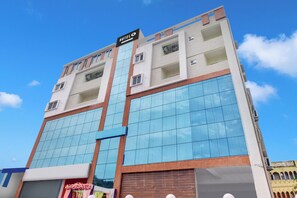Un hotel de varios pisos con un cartel grande que dice 'HOTEL', amplias ventanas de vidrio y un techo plano.