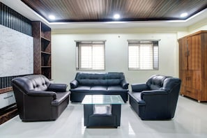 Una sala moderna con un conjunto de sofás, una mesa de centro y un armario de madera.