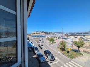 A parking lot with cars, a road, and a view of a marina with boats. - Amencer Máxico ~ Downtown • Harbor Views • Parking • Ideal for Couples (Baiona)