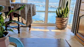 Ein Zimmer mit Blick auf eine Marina, ein Tisch mit einer Tasse und eine Topfpflanze.