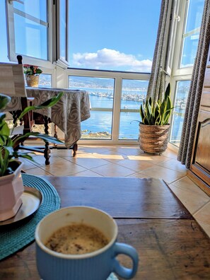 Ein Zimmer mit Blick auf eine Marina, ein Tisch mit einer Tasse und eine Topfpflanze.