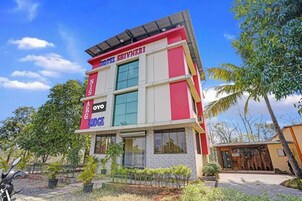 Un hotel de varios pisos con una fachada destacada de rojo y blanco, grandes ventanales y techo plano.