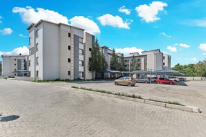 Un parking à plusieurs étages où sont garées plusieurs voitures.