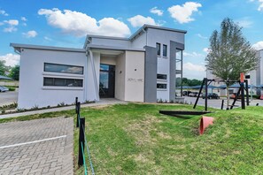A modern building with a flat roof, a glass entrance, and a sign that reads 'ACTIVITY CENTRE'. - Soho Junction Stylish 2-Bed Loft by ctha (Sandton)