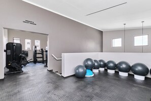 A gym with weightlifting equipment, exercise balls, and a sign indicating circuit training. - Soho Junction Stylish 2-Bed Loft by ctha (Sandton)
