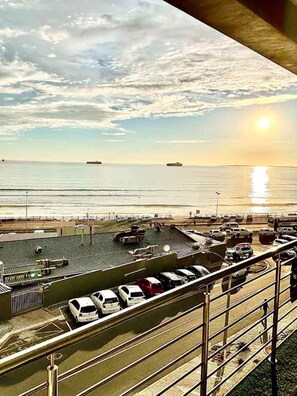 A parking lot with vehicles and a view of the sea and sky. - Wonderful 2-bedroom apartment in welcoming Bloubergstrand neighborhood (Cape Town)