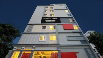 Ein mehrstöckiges Hotel mit einem Schild, das angibt, dass es von einer Firma bewirtschaftet wird.