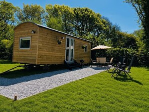 A wooden mobile home with a patio area, outdoor seating, and a grill. - Buzzards Lodge (Bodmin)