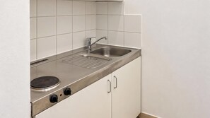 Eine Küche mit einer Edelstahlarbeitsplatte, einem Spülbecken und einem Herd.