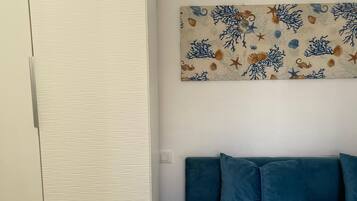 Una camera da letto con un letto, un armadio e un'opera d'arte appesa al muro.