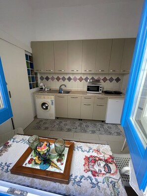 A compact kitchen with a washing machine, microwave, and a sink. - Apartment 'Il Sogno Di Fafa'' with Wi-Fi and Air Conditioning (Trapani)