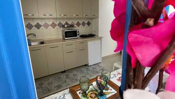 Una cucina con mobili, un forno a microonde e un lavello.
