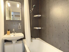 A bathroom with a white sink, a mirror, and a shower. - La Sapinette (4 People) Mountain views; Close to the slopes and the pool in the summer (Saint-Gervais-les-Bains)