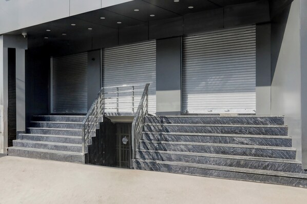 A set of marble stairs leading to a building entrance with closed shutters and a security camera. - Townhouse Vishwanath Temple Varanasi (Varanasi)