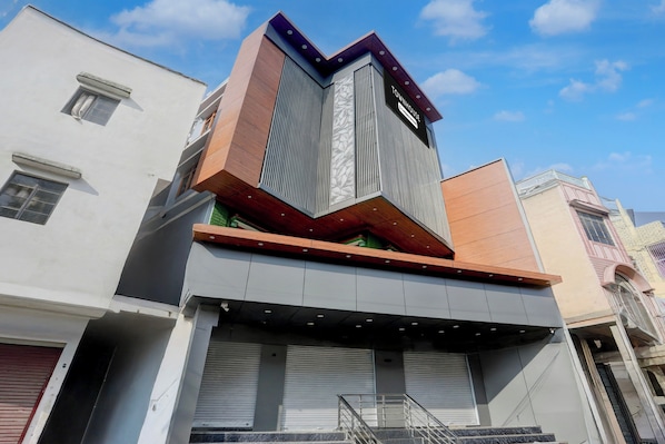 A modern building with a prominent corner entrance, a visible staircase, and a sign indicating it is a townhouse. - Townhouse Vishwanath Temple Varanasi (Varanasi)