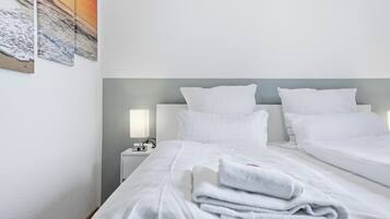 Ein Hotelzimmer mit zwei Betten, einem Nachttisch mit Lampe und einem Bild an der Wand.