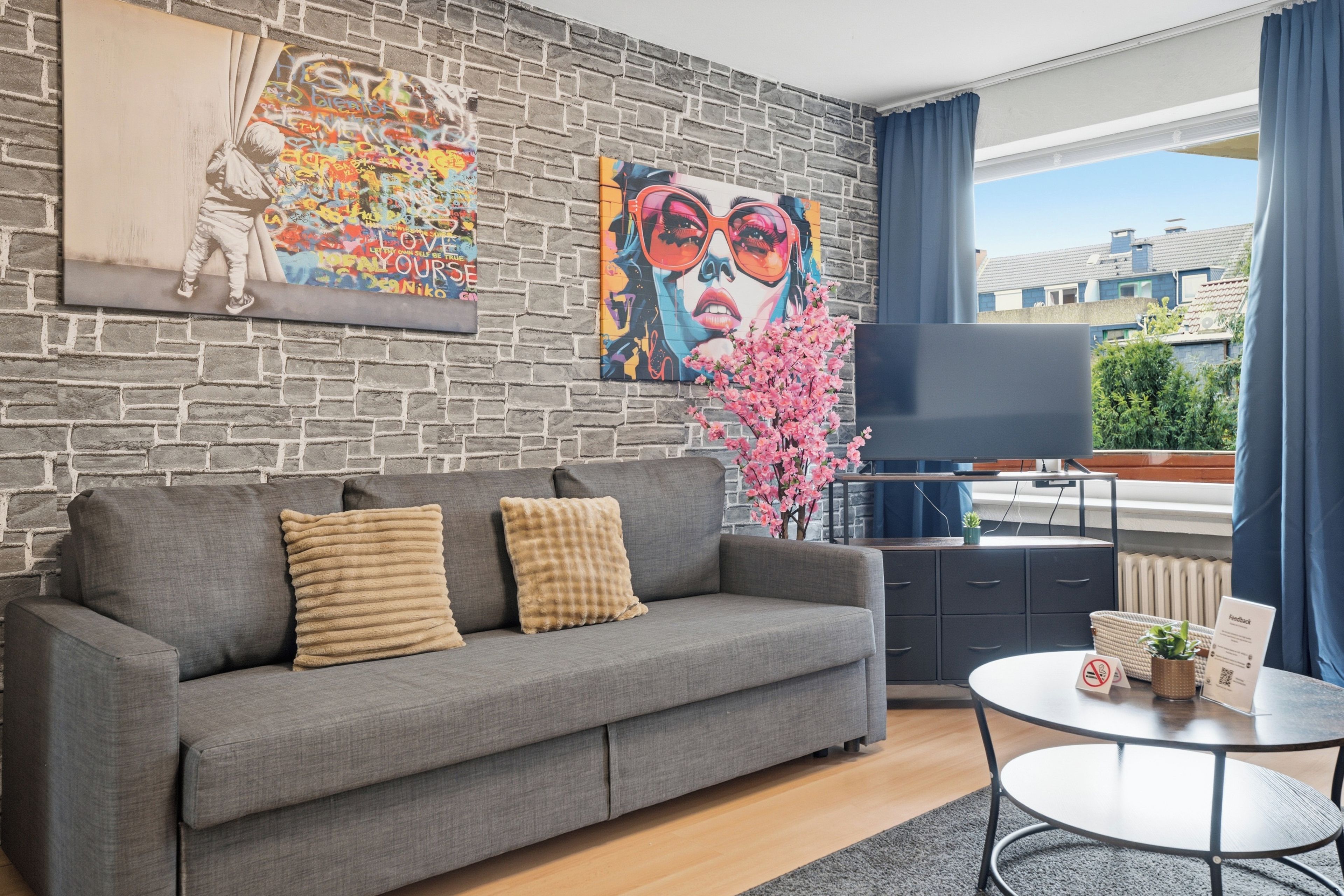 A modern living room with a grey sofa, a coffee table, and a TV.