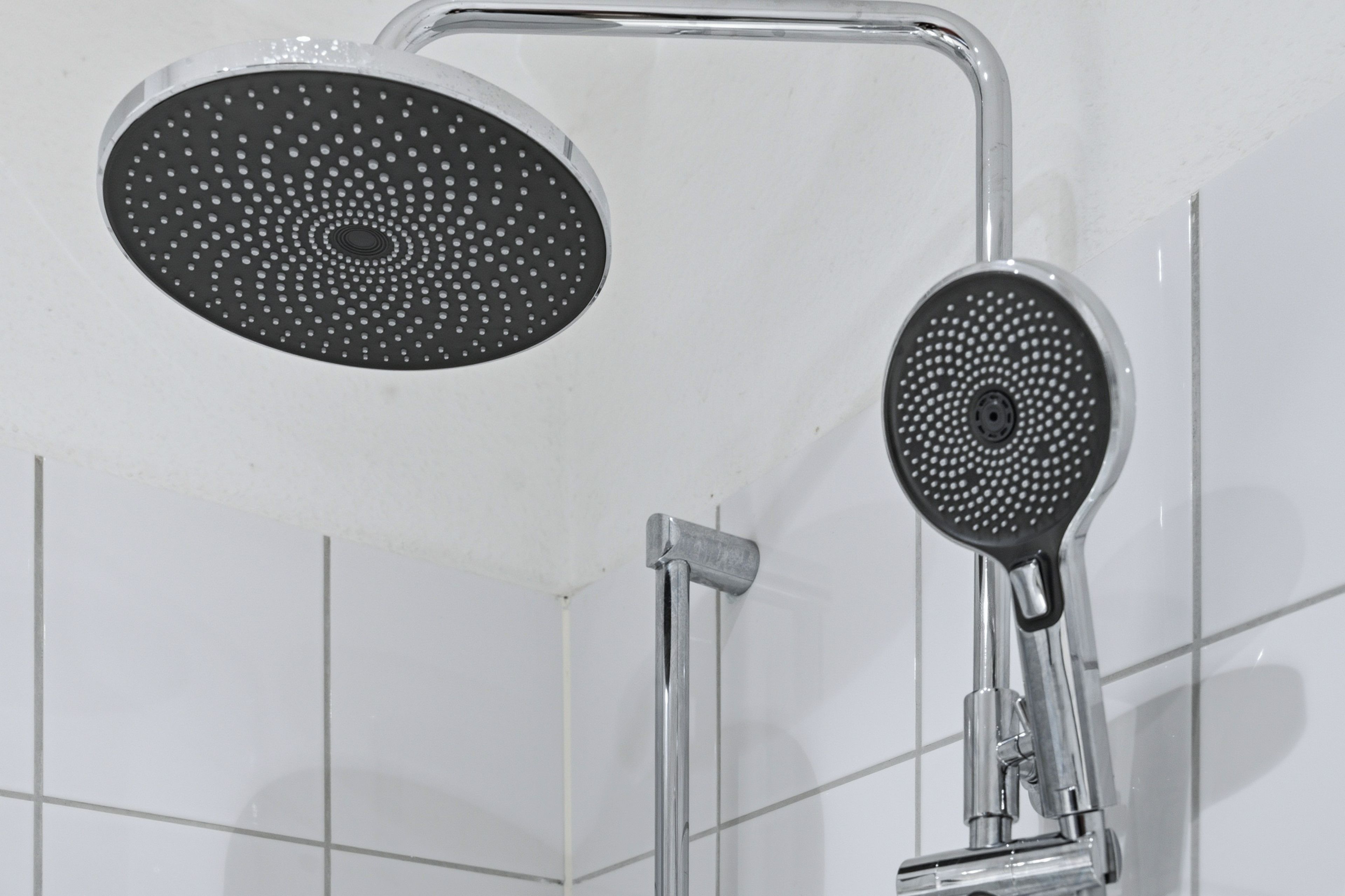 Eine Dusche mit Duschkopf und Handbrause.