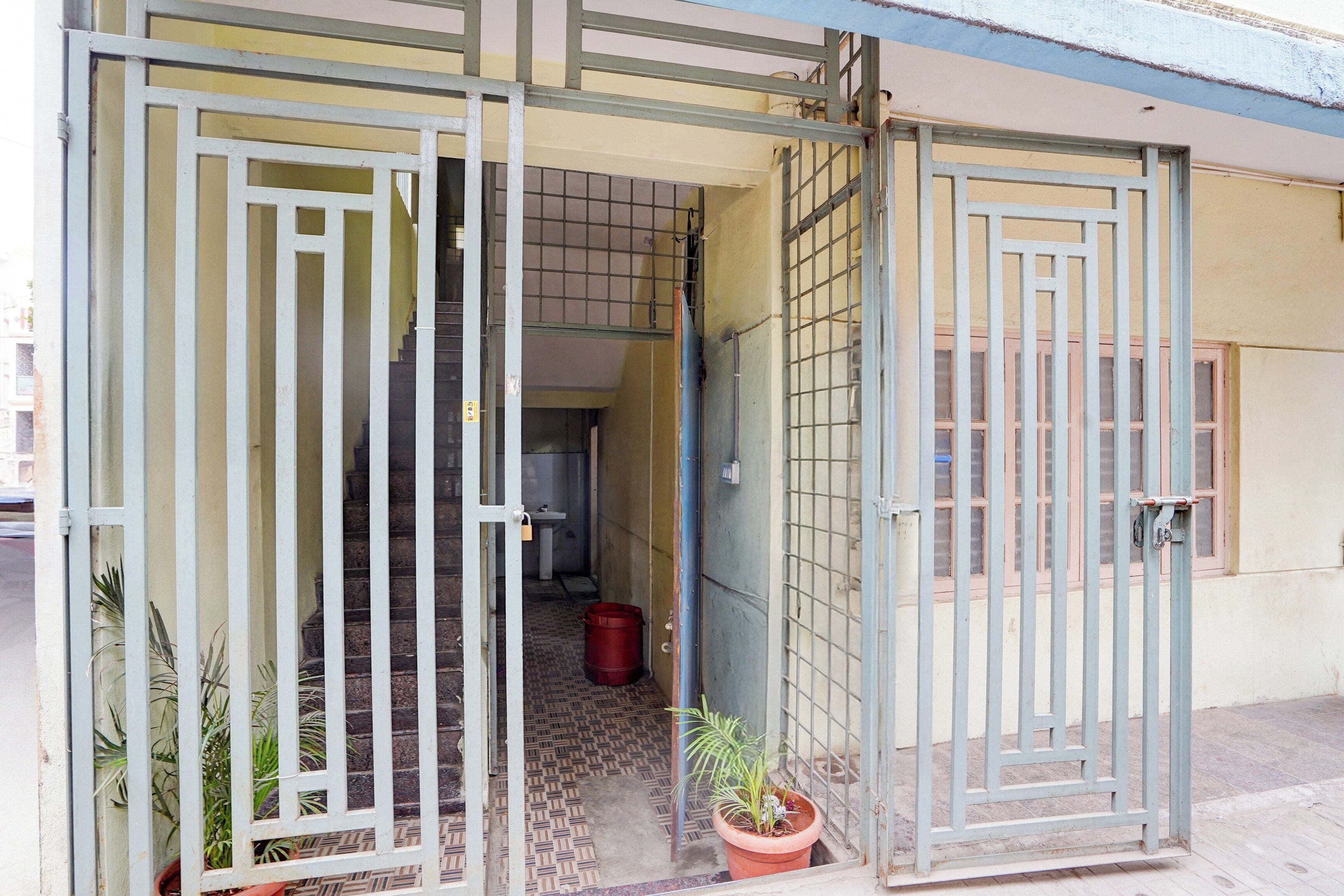 A gated entrance with a tiled floor and a potted plant.