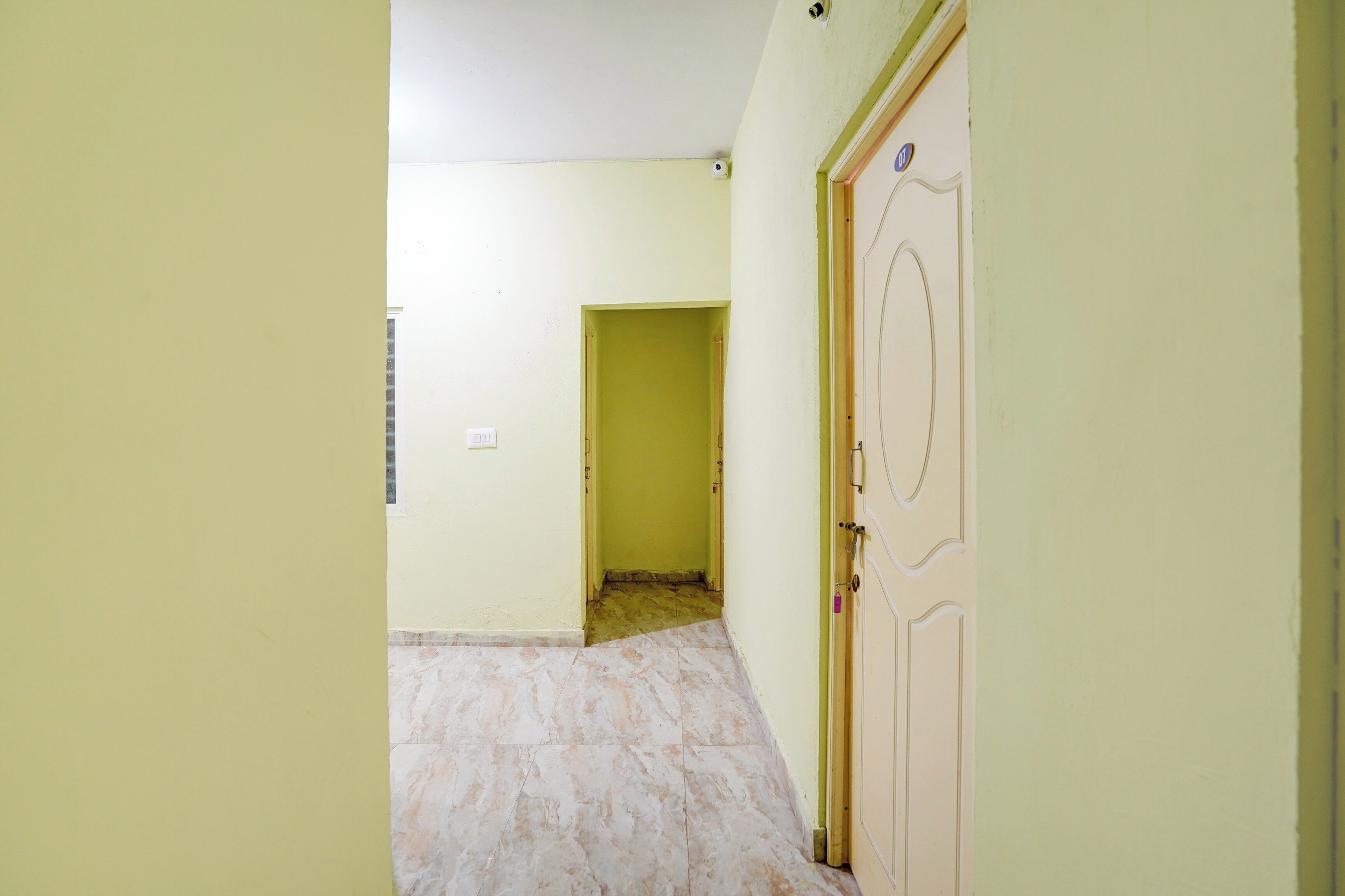 A hallway with a door on the right and a doorway at the end.