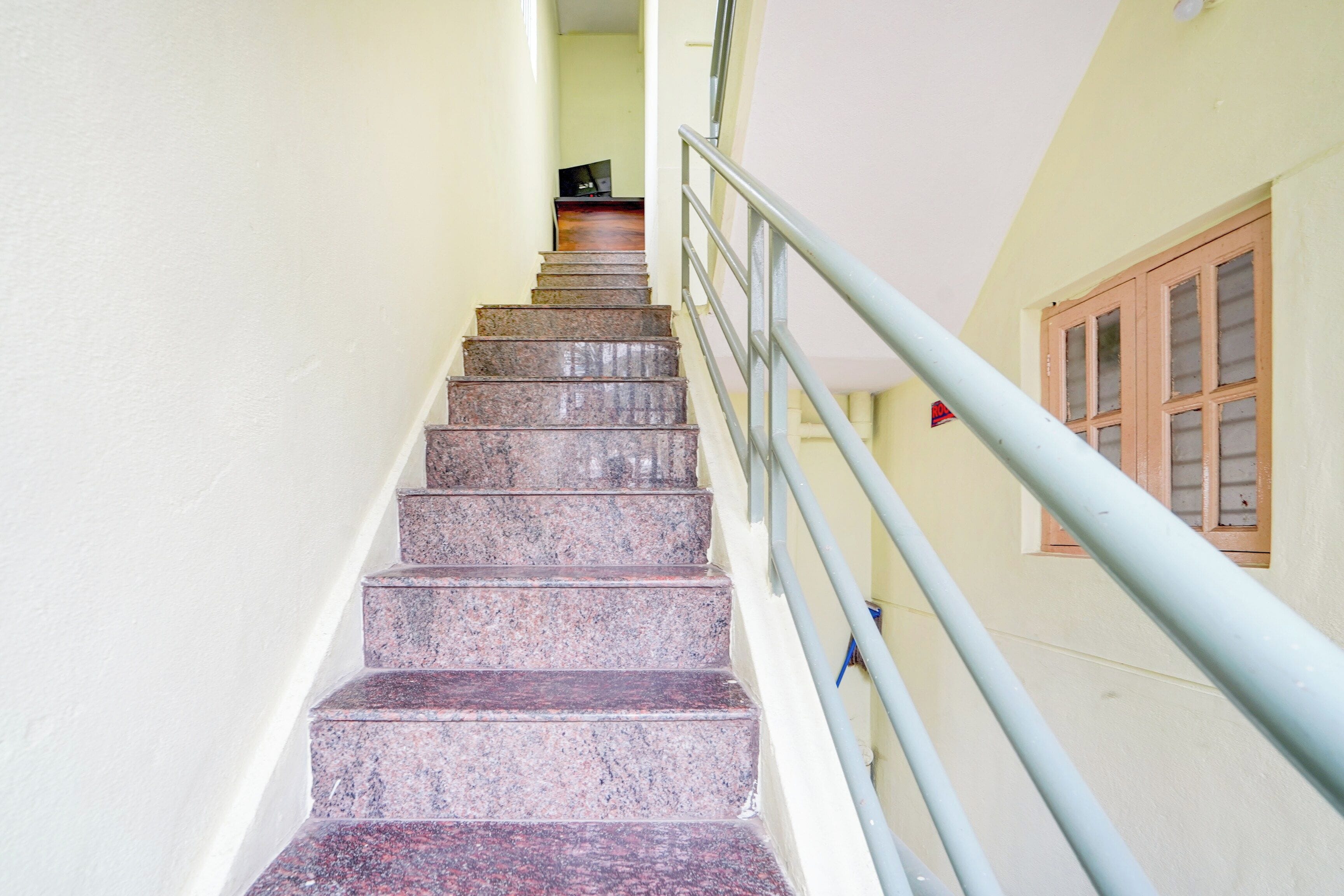 Una escalera con barandilla de metal que lleva a una plataforma.