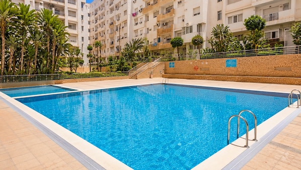 A rectangular swimming pool with clear blue water, surrounded by a tiled deck. - New Listing (Agadir)