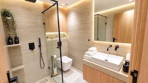 A modern bathroom with a glass-enclosed shower, a white sink, and a mirror above the sink. - New Listing (Agadir)