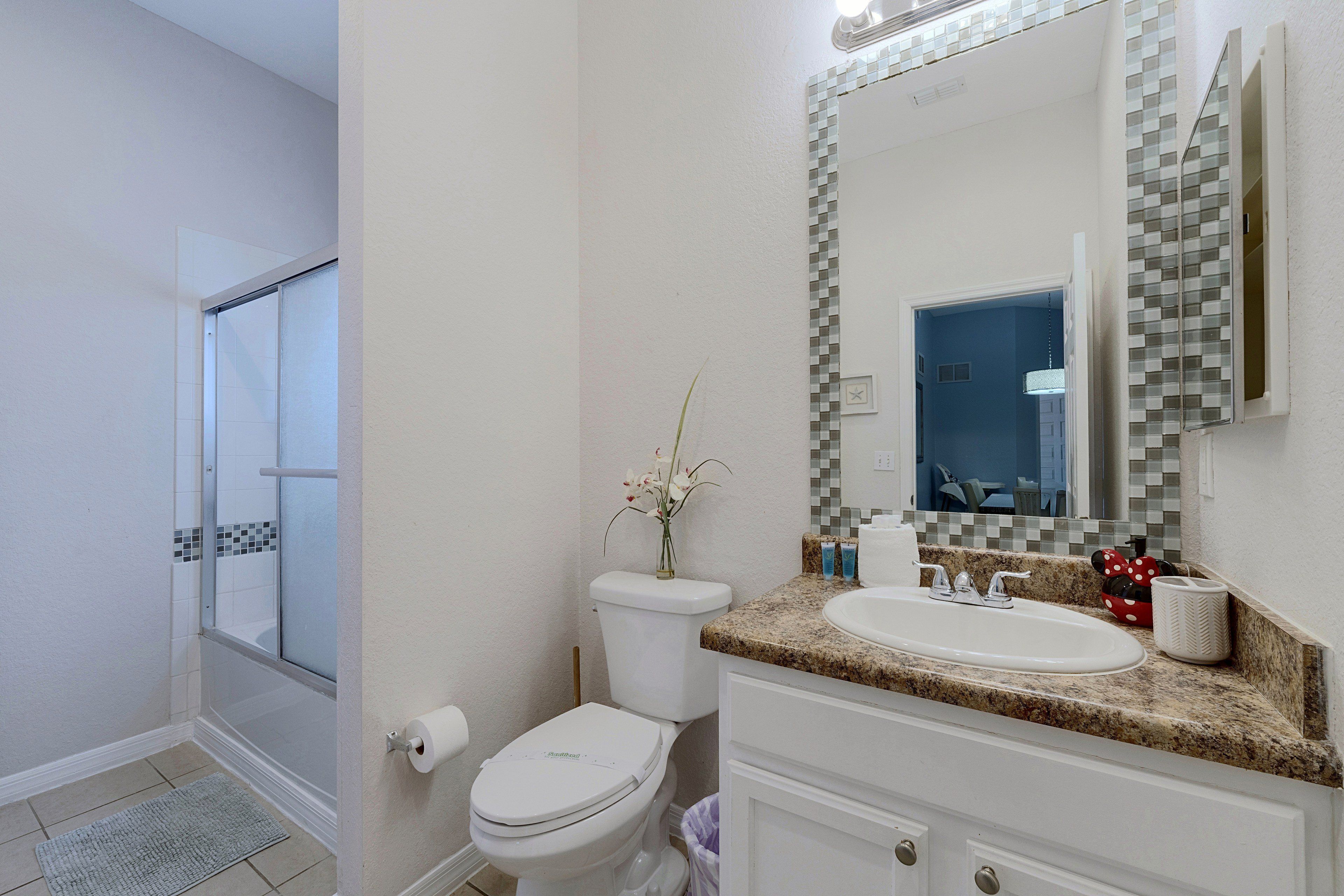 A bathroom with a toilet, sink, and shower area.