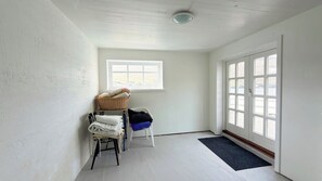 Un espace buanderie comprenant un lave-linge, un étendoir et une fenêtre donnant sur un paysage agréable.