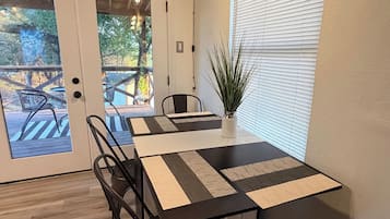 Uma sala de conferências com uma mesa, cadeiras, um vaso de planta e uma placa na parede.