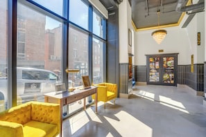 A hotel lobby with large windows, a reception desk, a chandelier, and a sign indicating commercial units are available. - 7th-floor Condo: Walk to Cafes, Dining & More (Chattanooga)