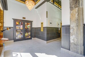 A hotel lobby with a chandelier, a reception desk, and a wall with a number sign. - 7th-floor Condo: Walk to Cafes, Dining & More (Chattanooga)