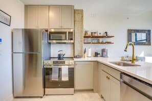 A modern kitchen with stainless steel appliances, wooden cabinets, and a built-in microwave. - 7th-floor Condo: Walk to Cafes, Dining & More (Chattanooga)