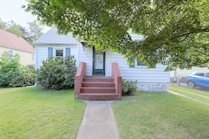A two-story house with a front porch, a brick staircase, and a small front yard. - Studio Guest Suite Outside Baltimore (Parkville)