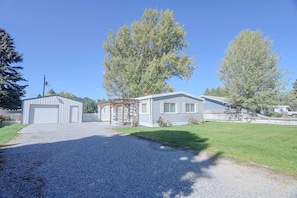Ein Wohnhaus mit Garage, überdachter Veranda und Rasengrundstück.