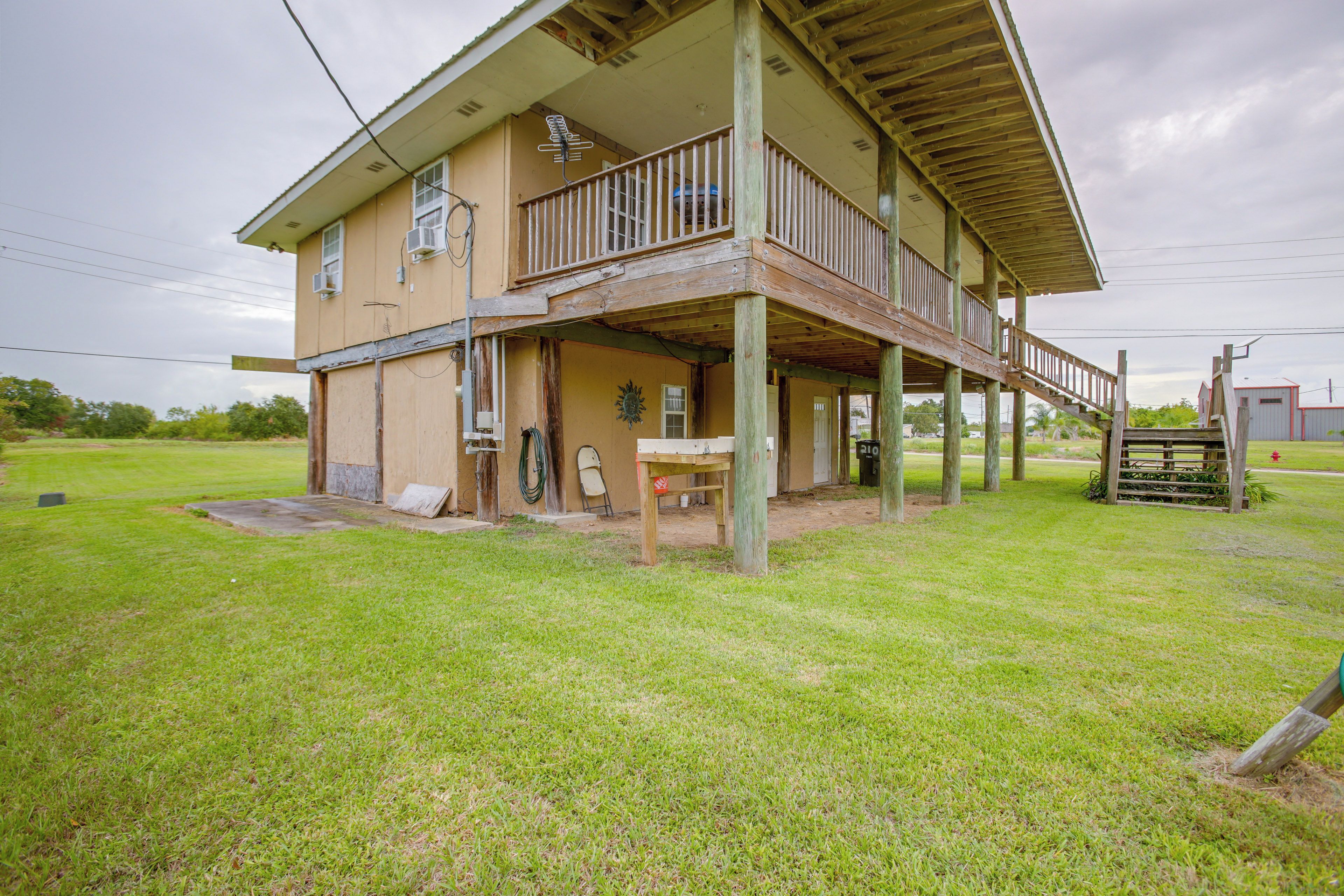 A two-story house with a balcony, a covered porch, and a grassy yard.