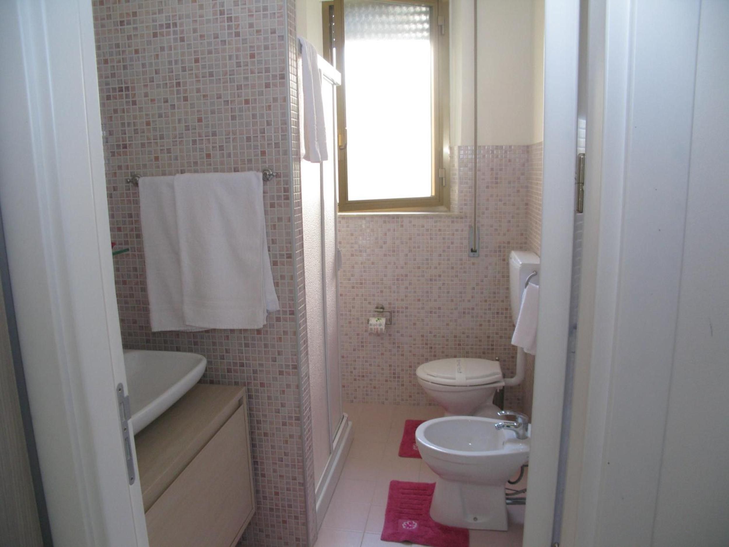 A bathroom with a toilet, bidet, and a shower area.