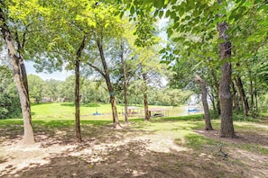 A park with trees, a grassy area, and a body of water.