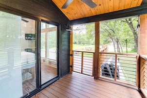 Una terraza de madera con un ventanal de vidrio que da a un espacio al aire libre.