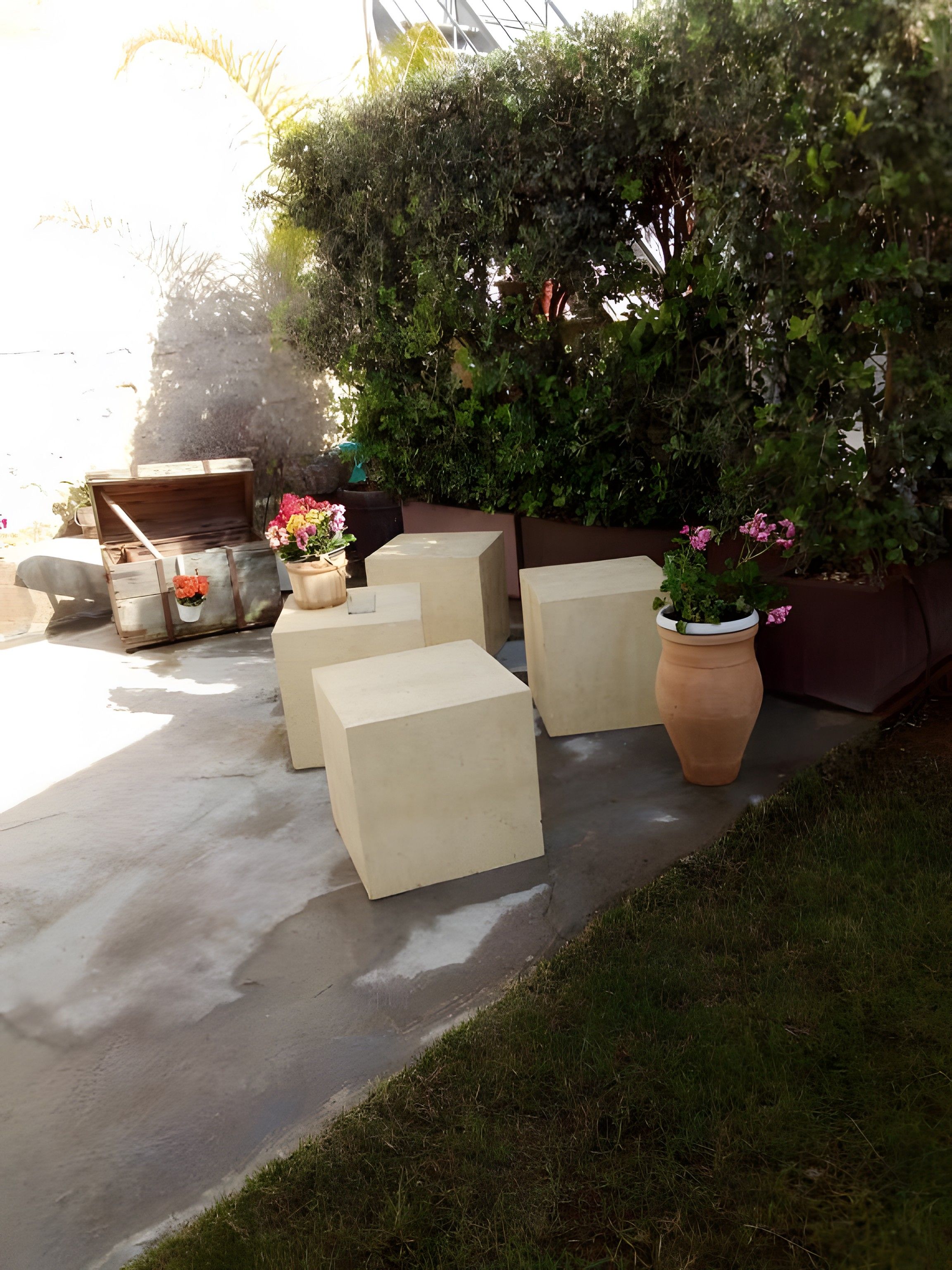 Outdoor seating with concrete blocks and potted plants.