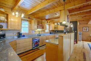Una cocina amplia con armarios de madera, encimeras de granito y electrodomésticos de acero inoxidable.