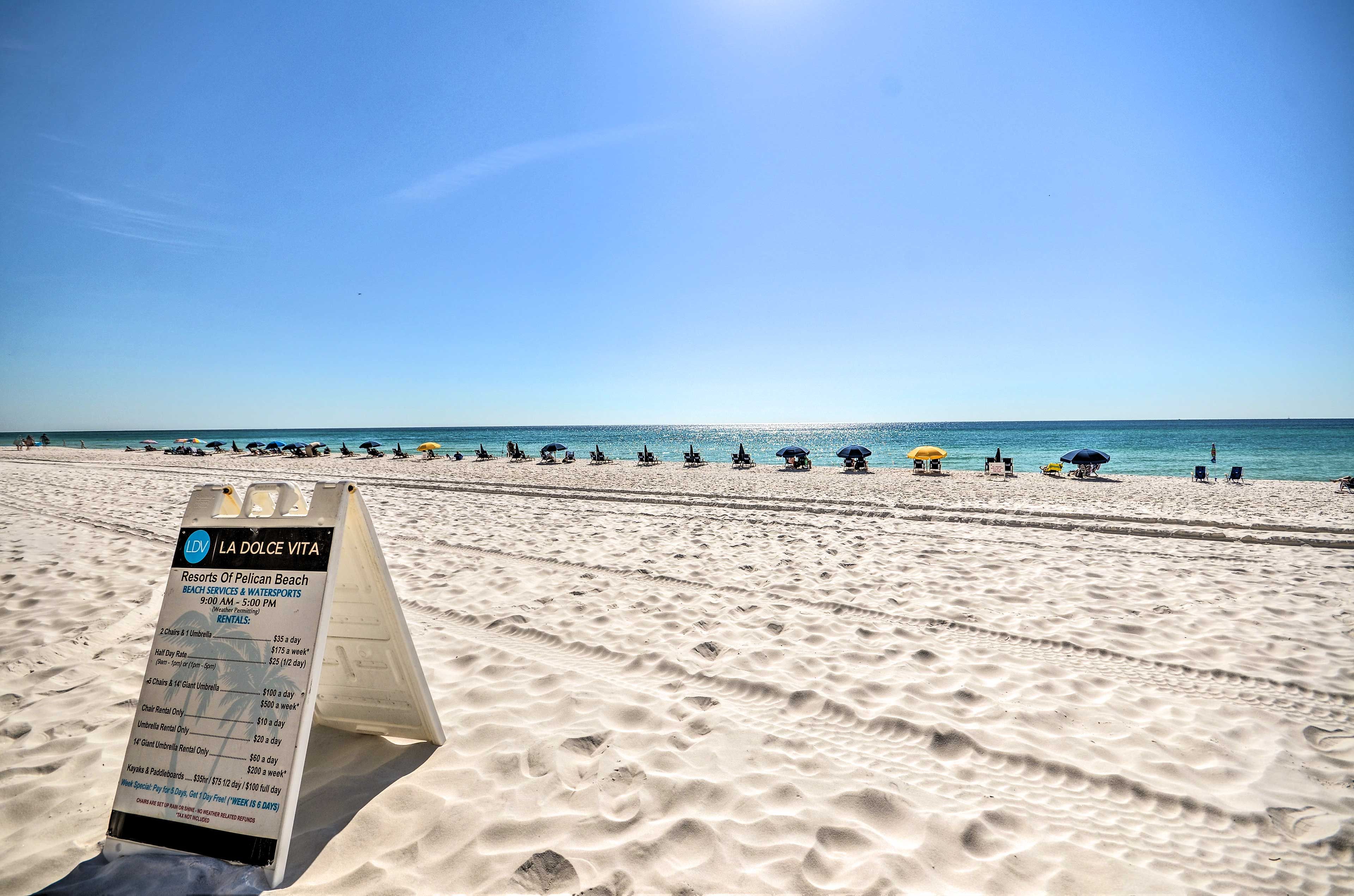 A beach with a signboard detailing amenities and rental prices.