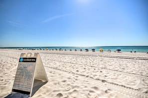 Ein Strand mit einem Schild, das Annehmlichkeiten und Mietpreise auflistet.