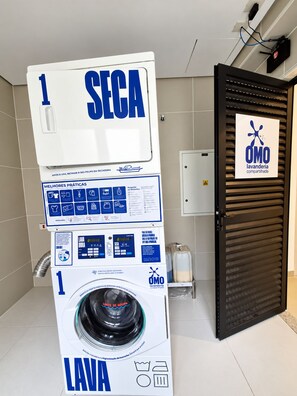 A public laundry facility with a large sign indicating the number 1 for the washing machine. - New Listing (São Paulo)