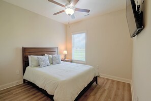 A bedroom with a bed, a nightstand, a lamp, a ceiling fan, and a window with blinds. - Stunning Murrells Inlet Townhome Near Marshwalk (Murrells Inlet)
