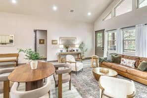 A spacious living room with a round wooden table, a sofa, and a bench. There is a dining area with a table and chairs, and a kitchen visible through an open door. - Golfers Oasis! Ponderosa Pine Retreat in Show Low (Show Low)